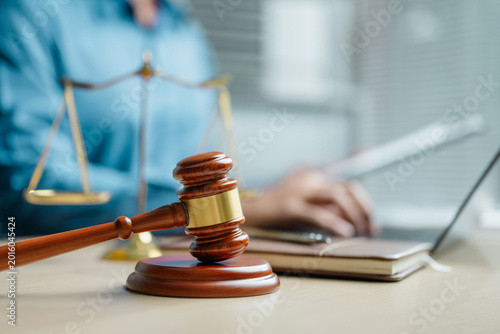 Quadro em tela Judge gavel and justice scale on office desk with professional working on laptop, representing legal services, court decisions, compliance, law firm operations and judicial authority