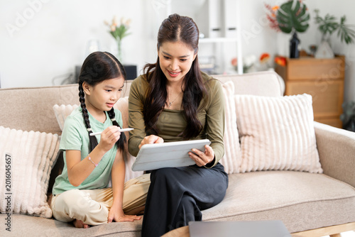 Asian Mother and Daughter Using Digital Tablet for E-learning at Home