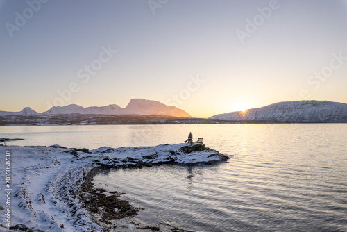 Relaxing on a snowy mountain viewpoint above Malangen Fjord
