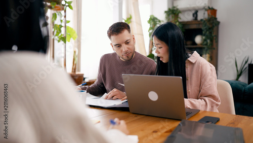 Εκτύπωση καμβά Couple reviewing documents and using a laptop while meeting with a financial adv