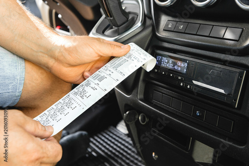 Obraz na płótnie Detailed view of tachograph paper printout in hand
