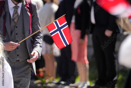 Hand Holding Small Norwegian Flag – Close-Up at Outdoor Syttende Mai National Day Celebration