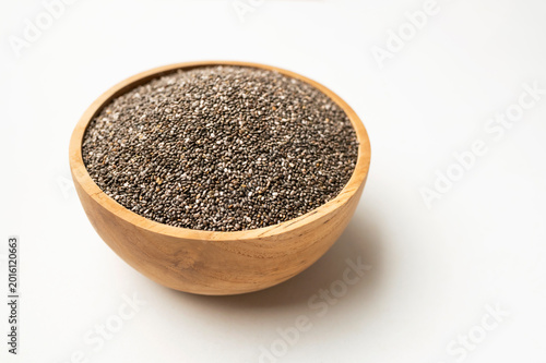 Organic chia seeds in wooden bowl on white background, top view. Superfood, source of omega-3 fatty acids and fiber. Healthy dried seeds of Salvia hispanica plant