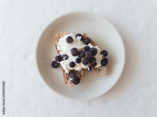 Bild auf Leinwand Minimalist table features blueberry toast with ricotta and natural light
