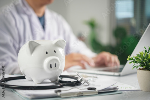 Obraz na plátně Piggy bank and stethoscope on doctor desk for medical savings and health insuran