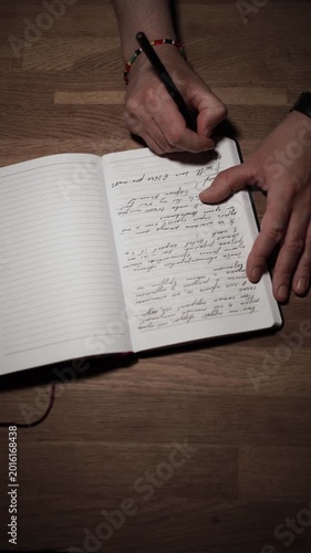Man Writing Notes in Open Notebook on Wooden Desk Close Up