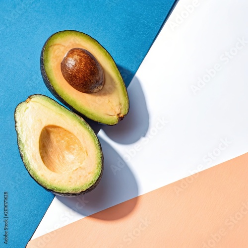 Fresh avocado halves on geometric pastel background healthy food concept