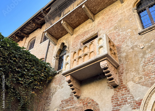 The iconic Juliet's Balcony in Verona, Italy, features medieval stonework, ivy-lined walls, and historic charm.