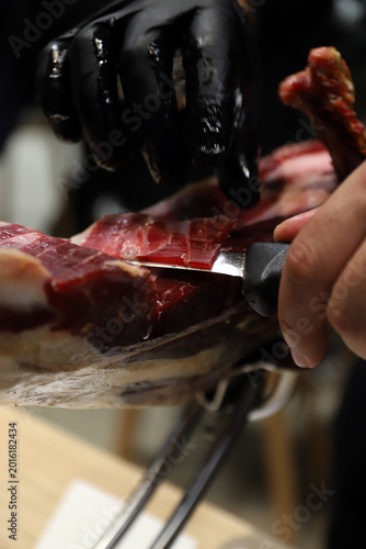 Fotografie chef cortando jamón ibérico de una paleta de jamón con cuchillo de corte de jamó