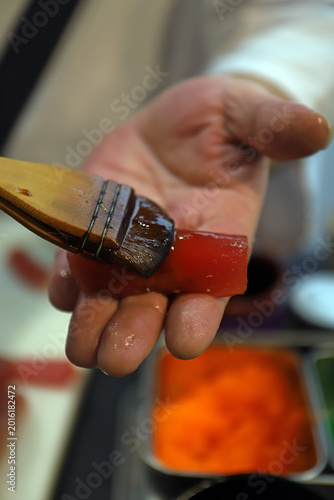 Quadro su tela experto chef en sushi elaborando sushi de atún rojo y arroz y dándole una pincel