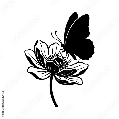 A black butterfly perches on a large flower in a natural setting.