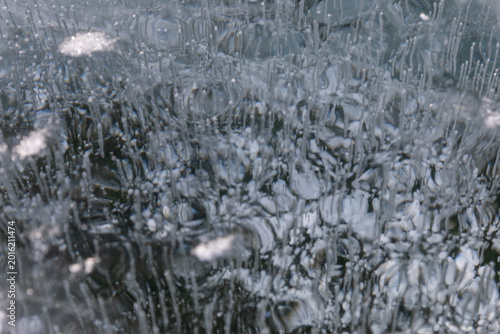 Obraz na plátně Close-up of clear winter ice with trapped air bubbles and crystalline patterns o