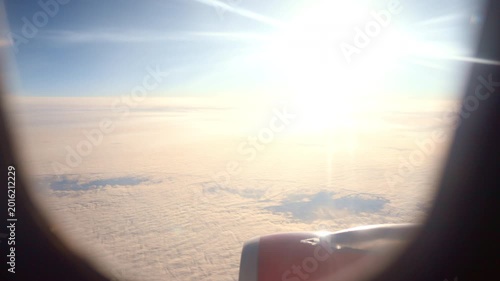 Serene Morning View Through Airplane Window. Gentle Sunrise Casting Glow On Peaceful Cloud Horizon. Tranquil Morning Scene With Warm Light Illuminating Soft Cloud Cover From Window