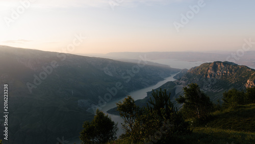 Wide scenic view of the Main Sulak Canyon with a winding river between steep mountain cliffs at sunset, Republic of Dagestan, Russia, calm summer landscape