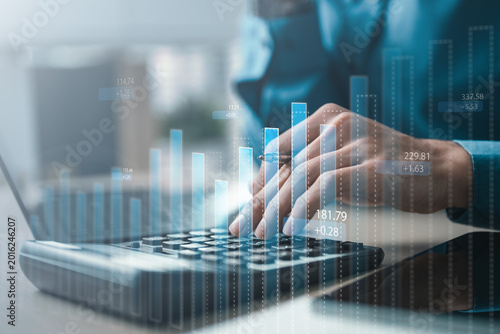 Close-up of professional using calculator with digital charts overlay, symbolizing financial analysis, investment planning, accounting audit, AI forecasting, market growth, and business performance.