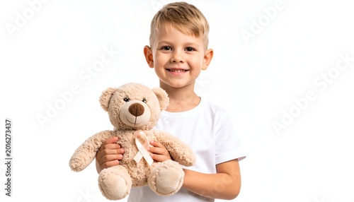 A young boy holding a teddy bear with a ribbon