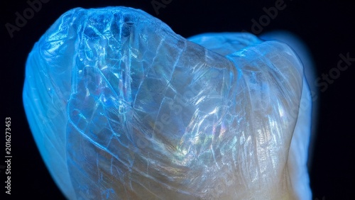 Iridescent tooth enamel with diamond-like cracks, glowing under blue light for durability.