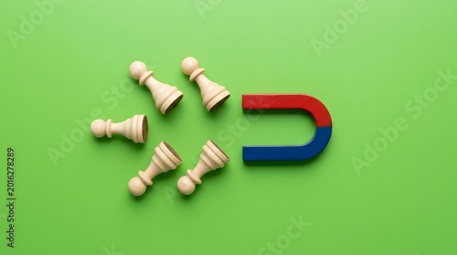 Magnet Attracting Wooden Chess Pawns on Green Background, Leadership and Recruitment Concept