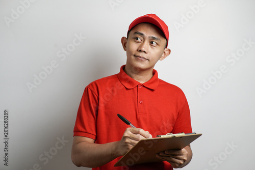 Asian Man in Red Uniform Thinking While Holding Clipboard and Pen