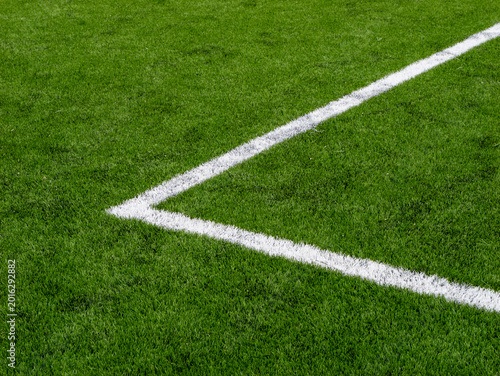 Corner marking on green football field grass with white painted lines