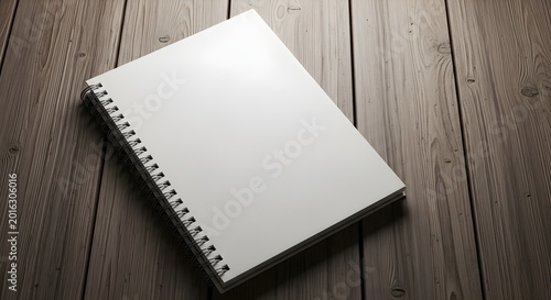 Closed spiral notebook with white cover on wooden table