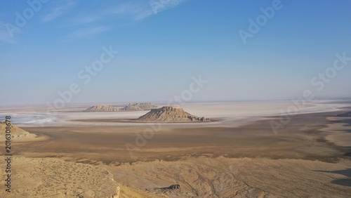 Desert Plateau Rises Above Salt Flats Under Clear Blue Sky