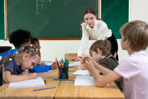 Diverse group of elementary school students learning together in classroom. Children participating in lesson, raising hands, studying, and engaging in educational activities at school.Back to School