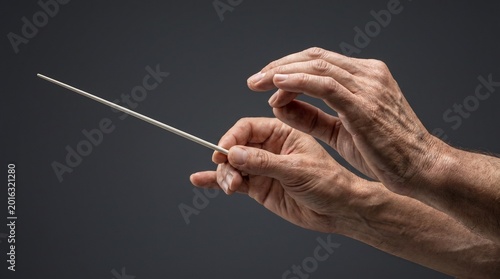 Close-up of elderly hands holding a thin wooden stick, concept of wisdom, precision or control