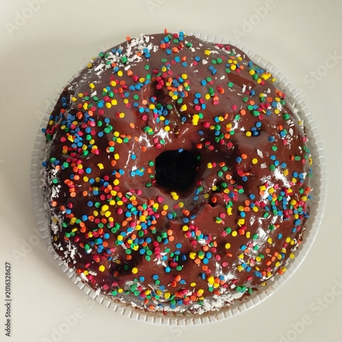 Fotografi Unrefined chocolate cake with frosting and multicolored sprinkles