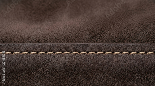 Close-up view of brown leather texture with detailed stitching, showcasing craftsmanship and material quality