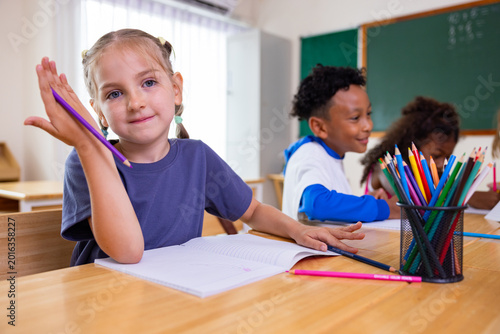 Fotografie Smiling Schoolgirl Studying with Classmates in Classroom