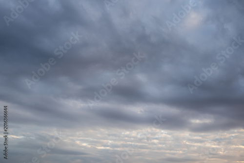 Tableau sur toile Layered cloudscape with dark stratus clouds sweeping across a blue-grey sky abov