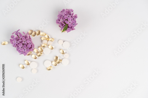Фотография Vitamin allergies relate to supplements and flowers on a plain background with p