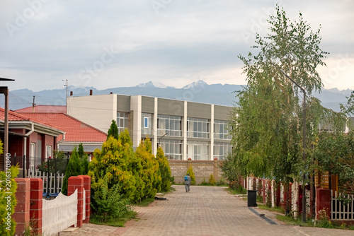 Cuadro en lienzo Residential Street in Cholpon Ata Beneath Snowy Kyrgyz Mountain Horizon