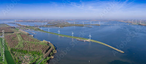 Wide panoramic aerial view of the Volkerakdam dyke with wind turbines, A29 motorway bridge and Volkerak waterway in the Netherlands
