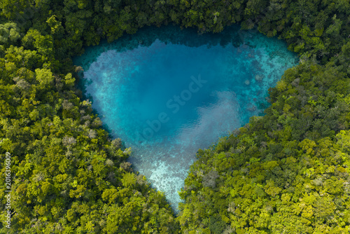 A small marine lake is surrounded by a limestone island covered by lush forest in Palau's lagoon. This island-nation is a popular destination for divers, snorkelers, kayakers, and World War II buffs. 