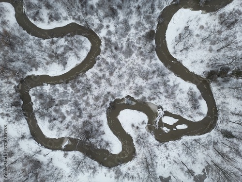 A vertical aerial view of a river's meanders in a snow-covered landscape - Vue aérienne à la verticale des méandres d'une rivière dans un paysage enneigé