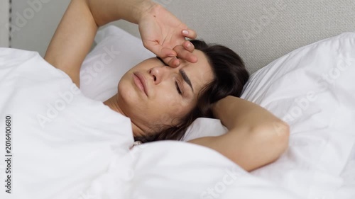 Young woman starting the day in bed with relaxed morning mood. Concept home lifestyle and wellbeing.
