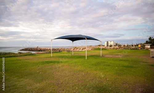 Canvas Print Blue shade sail on green lawn at beach foreshore with ocean view, Geraldton, Wes