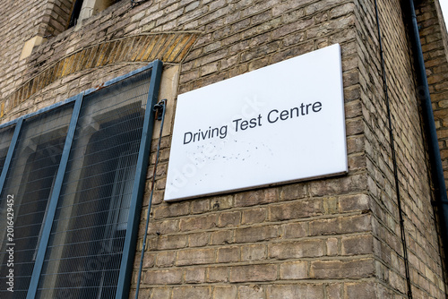 Fotografi A Driving Test Centre sign on the facade of a building.