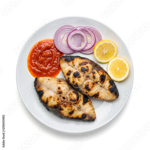 Grilled fish fillets served with red onions and lemon slices on a plate