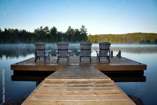 Back view of four wooden chairs on wooden dock