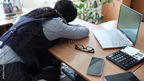 Business woman in a mask blindfolded asleep in the office. Exhausted employee in the workplace