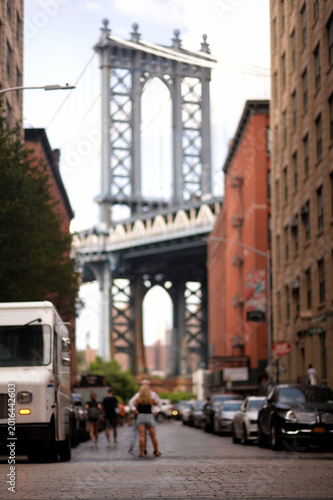Two Pedestrians Navigate Ancient Bridge Amid Old Industrial Warehouses new york