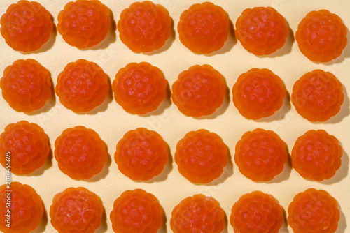 Jelly gummies close-up, fruit vitamins raspberry shaped, food supplements.Orange vitamins candies, top view