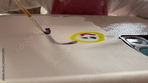 Child painting a picture with watercolors.