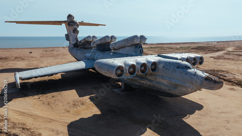 Fotografija Rusting abandoned Soviet ekranoplan aircraft sits on a sandy shoreline by the Ca