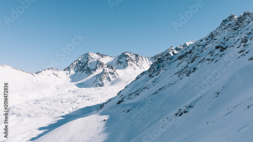 Foto Panoramic winter view of snow-covered mountain ridges and alpine valley near Kar