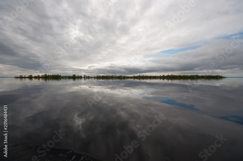 Clouds reflected on the calm surface of the lake Inari in Lapland, Finland in summer