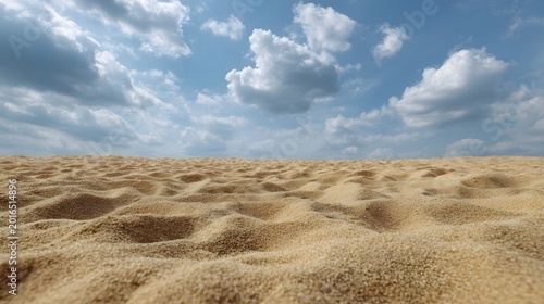 Rippled sand foreground contrasted against a vast dynamic blue sky filled with scattered white clouds